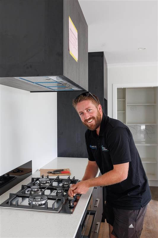 Gasfitter fixing a cooktop